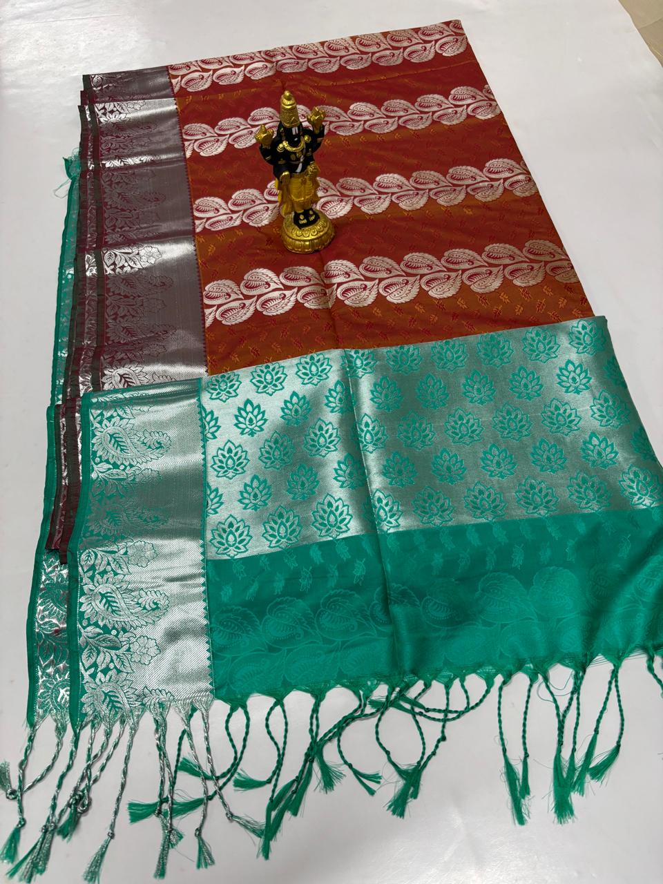 Brick red Elampillai silk cotton saree with teal green border and silver zari motifs