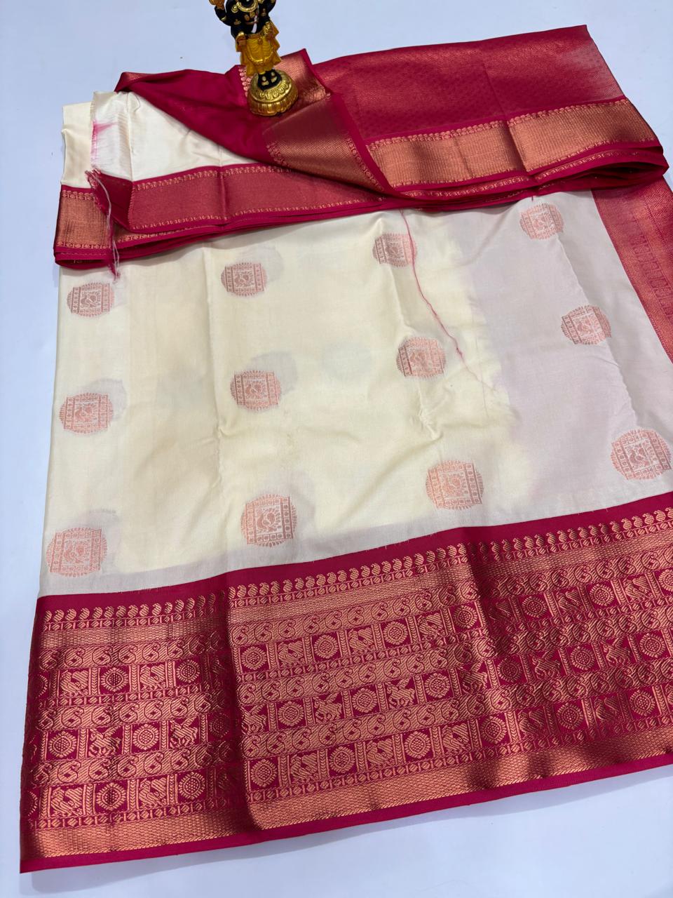 Cream Elampillai silk saree with magenta border and copper square zari buttas.