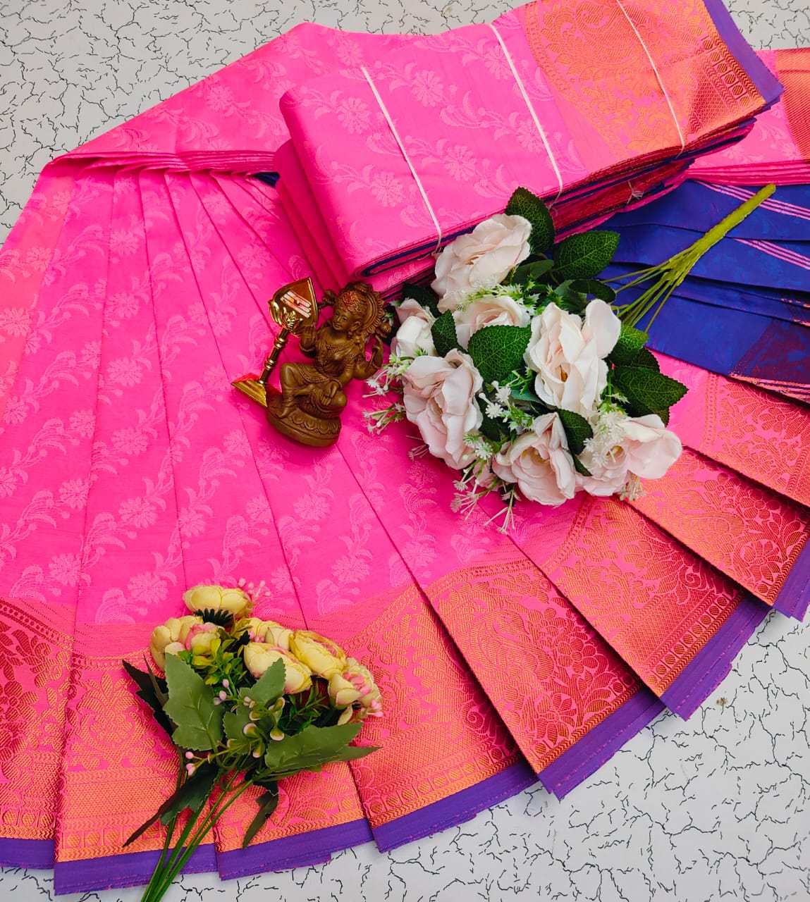 Bright pink saree with purple zari border and floral motifs