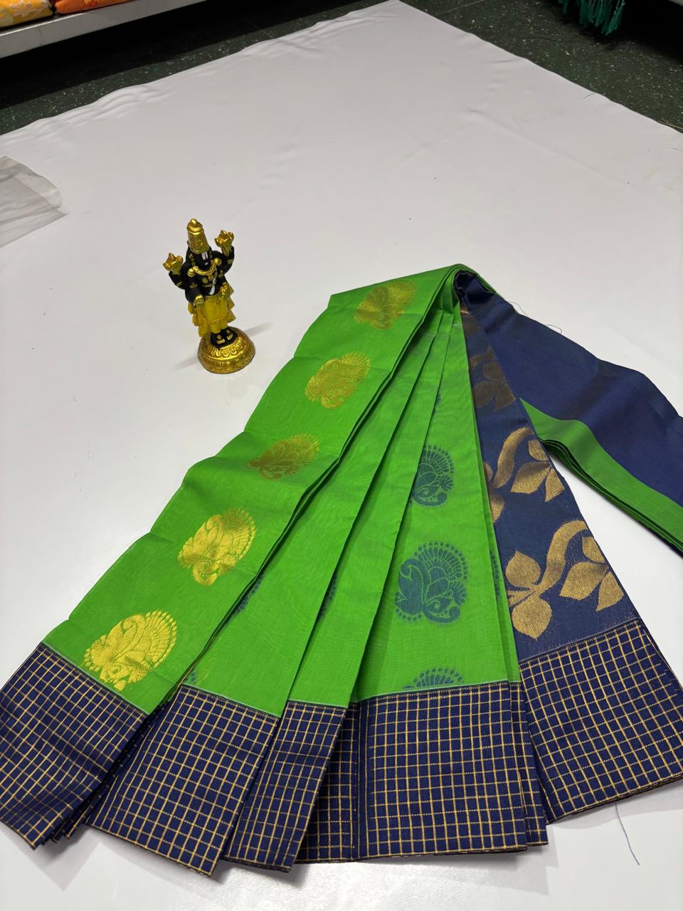 Bright green silk cotton saree with gold zari motifs and navy blue border