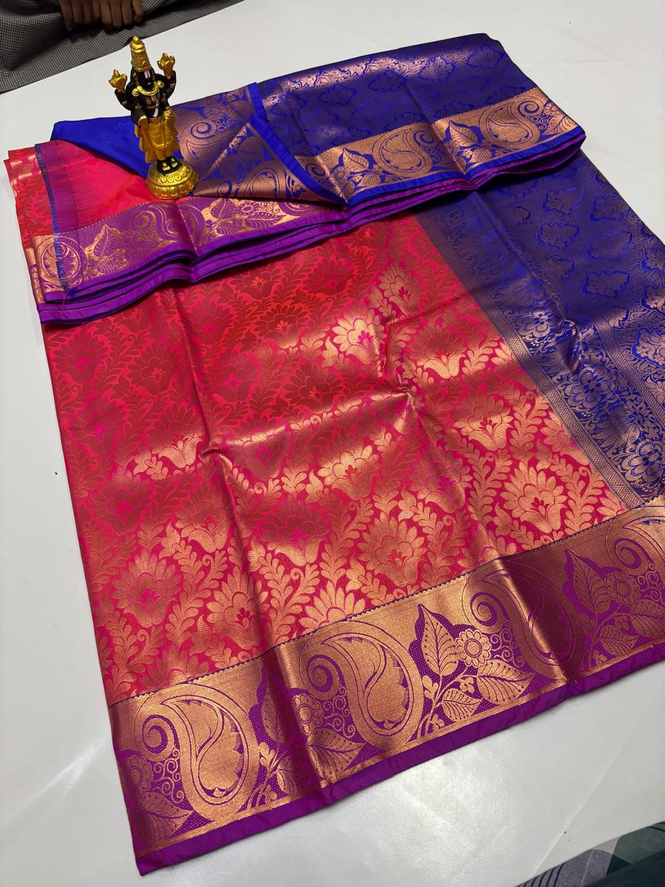 Coral red Elampillai saree with violet paisley zari border.