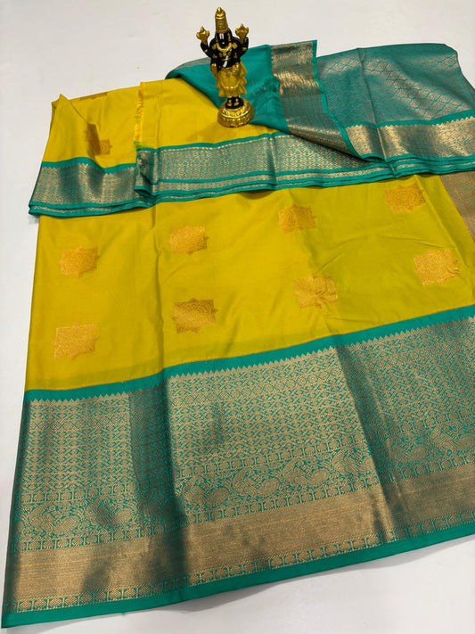 Bright yellow Elampillai silk saree with Rama green border and large gold zari geometric buttas.