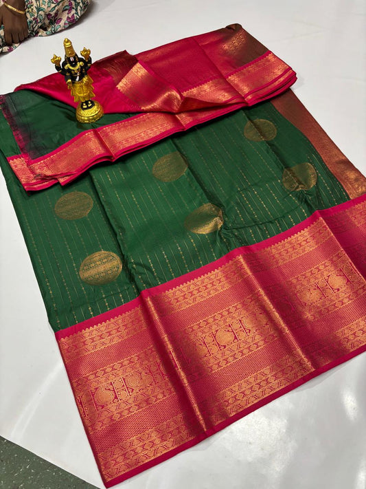 Deep forest green Elampillai silk saree with pink border and large circular gold zari buttas.