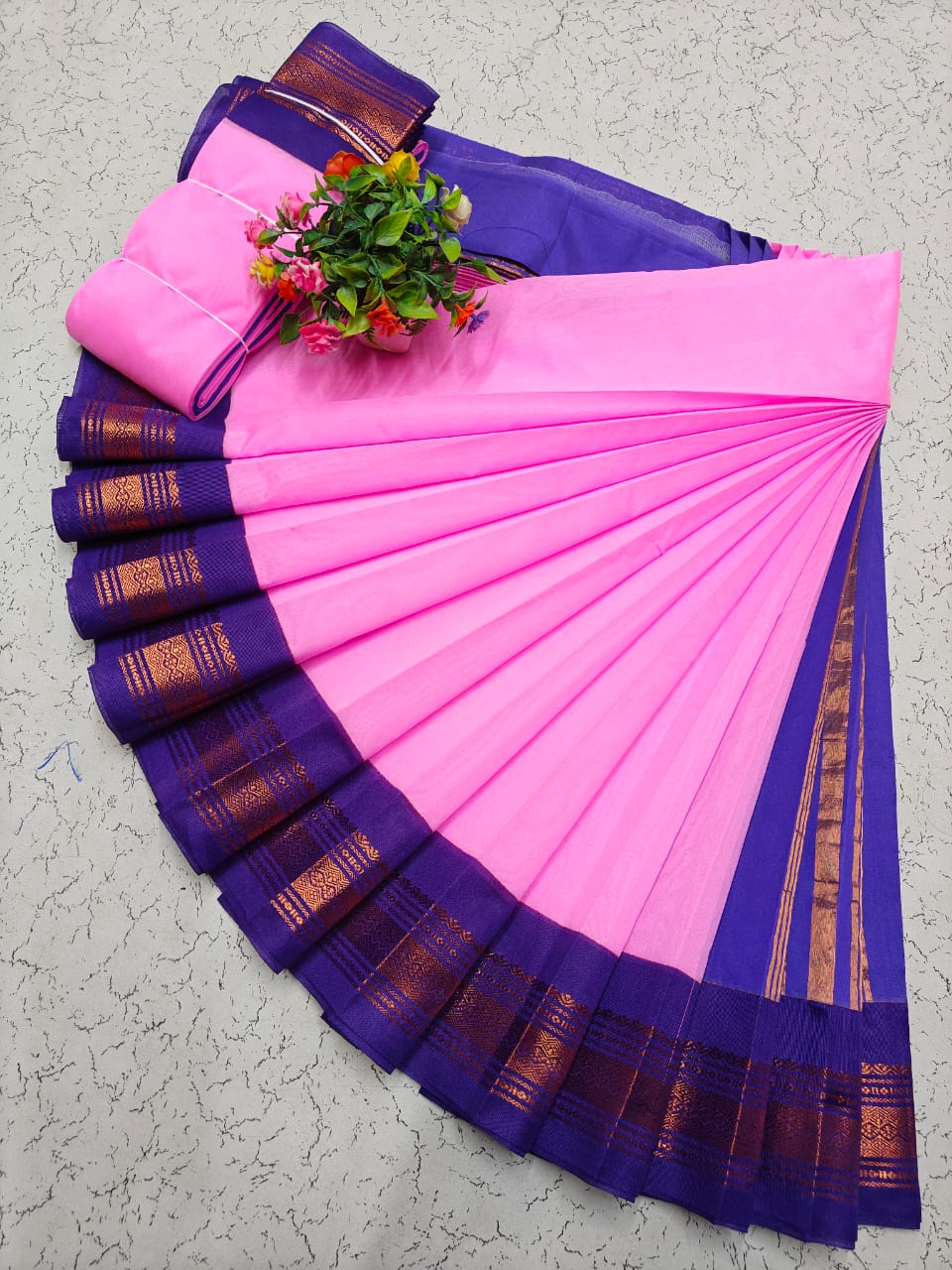 Baby pink Elampillai saree with a contrasting royal blue zari border and gold motifs.